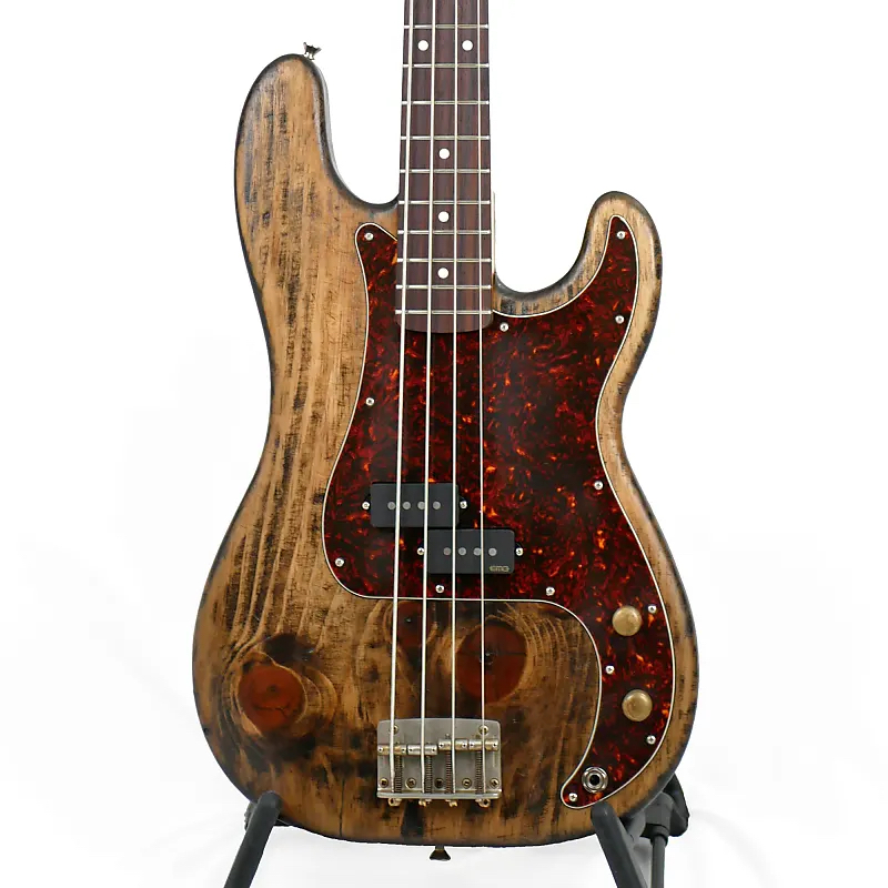 Image is of the front of an Offbeat Guitars Model P 34" Long-Scale Bass in Driftwood Brown on Distressed Pine