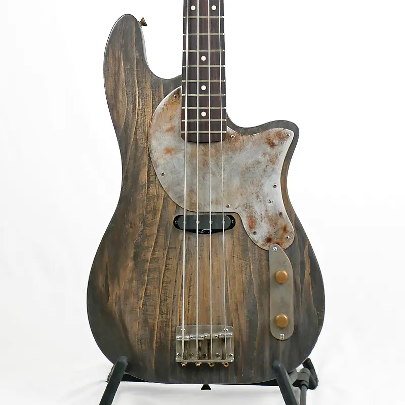 Image of the front of an Offbeat Guitars Priscilla 34" Long-Scale Bass in Shipyard Gray on Distressed Pine