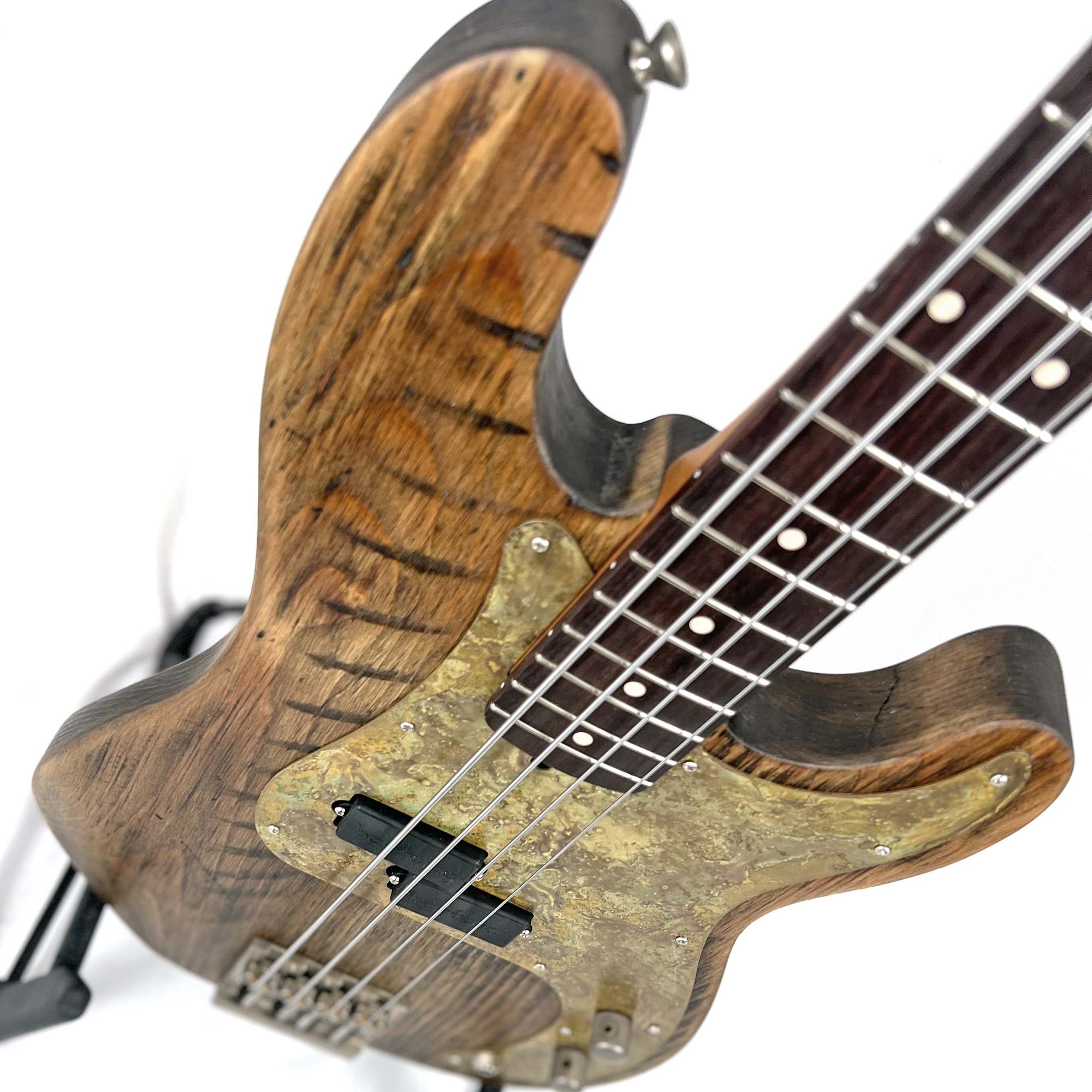 Closeup of an Offbeat Guitars Pamela P 34" Long-Scale Bass in Barn Brown on Distressed Pine with a Bartolini Pickup